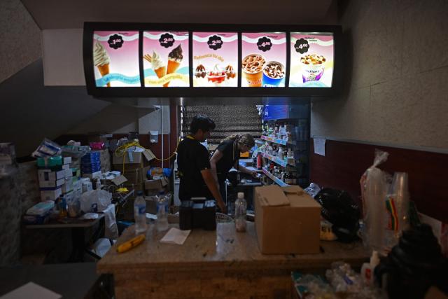 Health workers organize medical supplies inside a makeshift medical center set up in a former McDonald’s restaurant in Caraballeda, La Guaira, Venezuela, on July 3, 2026. The death toll from Venezuela's twin earthquakes has risen to 2,595, Interim President Delcy Rodriguez said on July 2. (Photo by Juan BARRETO / AFP)