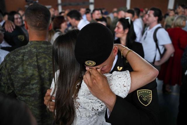 A tearful Kosovo Security Force (KSF) cadet hugs a family member during a graduation ceremony at Adem Jashari barracks in Pristina on July 3, 2026. (Photo by Armend NIMANI / AFP)