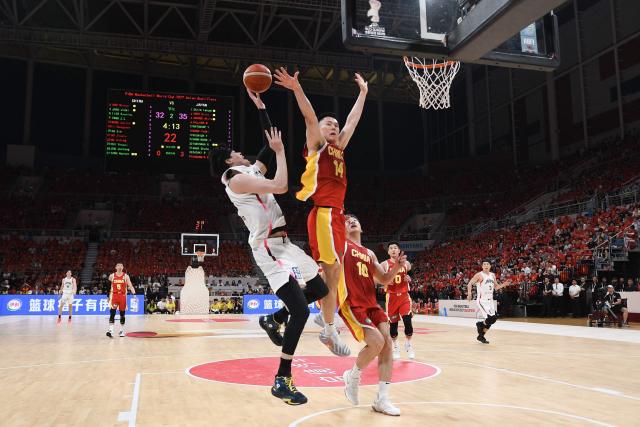 Japan's Yuta Watanabe (L) shoots next to China’s Li Hongquan (C) during the FIBA Basketball World Cup 2027 Asian Qualifiers game between China and Japan in Shenyang, China’s Liaoning Province on July 3, 2026. (Photo by CN-STR / AFP) / China OUT