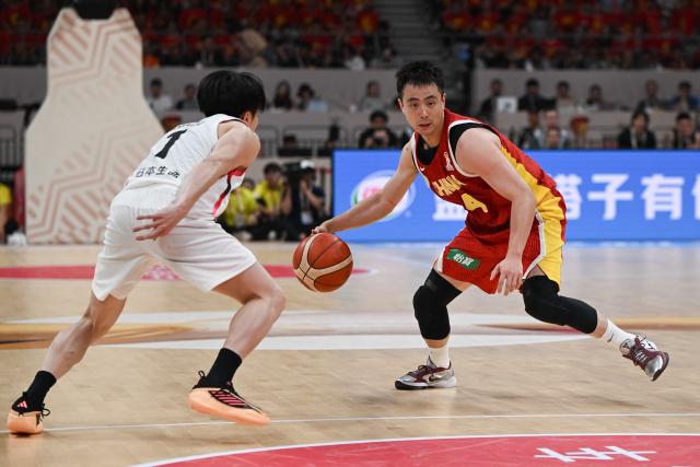 China’s Zhao Jiwei controls the ball next to Japan’s Takumi Saito during the FIBA Basketball World Cup 2027 Asian Qualifiers game between China and Japan in Shenyang, China’s Liaoning Province on July 3, 2026. (Photo by CN-STR / AFP) / China OUT
