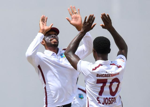 Roston Chase (L) and Shamar Joseph (R) of West Indies celebrate the dismissal of Dinesh Chandimal of Sri Lanka during day one of the second Test cricket match between West Indies and Sri Lanka at Sir Vivian Richards Stadium in North Sound, Antigua and Barbuda, on July 3, 2026. (Photo by Randy Brooks / AFP)