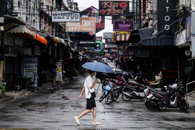 A man walks across a street as it rains in Pattaya on July 3, 2026. (Photo by ANTHONY WALLACE / AFP)
