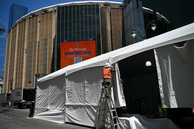 A worker makes adjustments to a tent outside Madison Square Garden, the reported venue for the wedding celebrations of pop singer Taylor Swift and pro-athlete Travis Kelce, in New York City on July 3, 2026. Swift and Kelce's official wedding plans are tightly under wraps, but New York is bracing to host the celebrity marriage of the year this week at Madison Square Garden. The wedding will reportedly take place Friday with a star-studded guest list of around 1,000, including models Gigi Hadid and Cara Delevingne, singer Selena Gomez, and actress Zoe Kravitz -- all known to be close Swift pals -- and Kelce's Kansas City Chiefs teammates. (Photo by ANGELA WEISS / AFP)