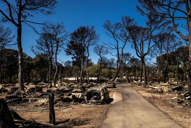 This photograph shows debris and burnt-out cars at the camping 'Le Brasilia', a day after a fire broke out, in Canet-en-Roussillon, southern France on July 3, 2026. Nearly 3,000 people had to be evacuated from several campsites, as well as from businesses and several municipalities, after a fire broke out in Sainte-Marie-la-Mer and spread on to Canet-en-Roussillon, affecting the watersports hub, firefighters and the prefect of Pyrenees-Orientales said on July 2, 2026. (Photo by Jean-Christophe MILHET / AFP)