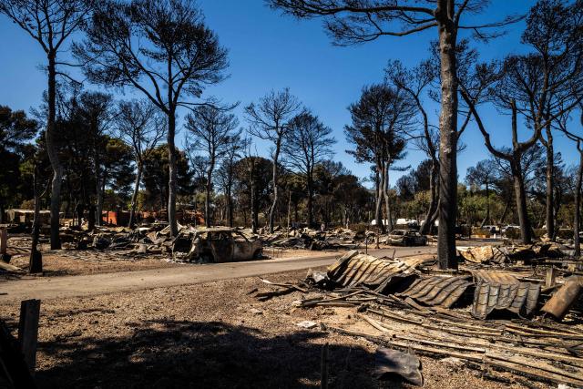 This photograph shows debris and a burnt-out car at the camping 'Le Brasilia', a day after a fire broke out, in Canet-en-Roussillon, southern France on July 3, 2026. Nearly 3,000 people had to be evacuated from several campsites, as well as from businesses and several municipalities, after a fire broke out in Sainte-Marie-la-Mer and spread on to Canet-en-Roussillon, affecting the watersports hub, firefighters and the prefect of Pyrenees-Orientales said on July 2, 2026. (Photo by Jean-Christophe MILHET / AFP)