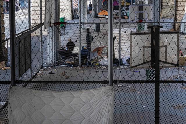 Homeless men speak with each other at a makeshift camp set up beneath the elevated Stalingrad metro station in Paris on July 3, 2026. (Photo by JOEL SAGET / AFP)