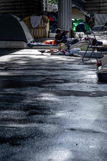 A man lies on a mattress at a makeshift camp set up beneath the elevated Stalingrad metro station in Paris on July 3, 2026. (Photo by JOEL SAGET / AFP)