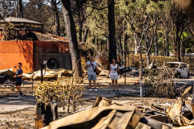 People look at debris in the camping 'Le Brasilia', a day after a fire broke out, in Canet-en-Roussillon, southern France on July 3, 2026. Nearly 3,000 people had to be evacuated from several campsites, as well as from businesses and several municipalities, after a fire broke out in Sainte-Marie-la-Mer and spread on to Canet-en-Roussillon, affecting the watersports hub, firefighters and the prefect of Pyrenees-Orientales said on July 2, 2026. (Photo by Jean-Christophe MILHET / AFP)