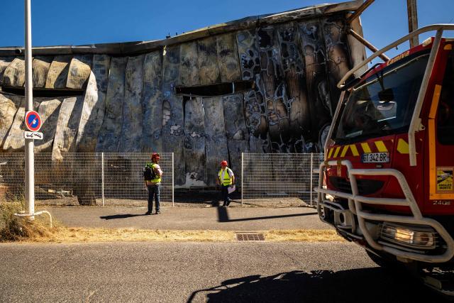 Experts inspect a damaged building of 'Catana Group', a company that manufactures and sells catamarans, a day after a fire broke out, in Canet-en-Roussillon, southern France on July 3, 2026. Nearly 3,000 people had to be evacuated from several campsites, as well as from businesses and several municipalities, after a fire broke out in Sainte-Marie-la-Mer and spread on to Canet-en-Roussillon, affecting the watersports hub, firefighters and the prefect of Pyrenees-Orientales said on July 2, 2026. (Photo by Jean-Christophe MILHET / AFP)