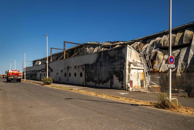 This photograph shows a damaged building of 'Catana Group', a company that manufactures and sells catamarans, a day after a fire broke out, in Canet-en-Roussillon, southern France on July 3, 2026. Nearly 3,000 people had to be evacuated from several campsites, as well as from businesses and several municipalities, after a fire broke out in Sainte-Marie-la-Mer and spread on to Canet-en-Roussillon, affecting the watersports hub, firefighters and the prefect of Pyrenees-Orientales said on July 2, 2026. (Photo by Jean-Christophe MILHET / AFP)