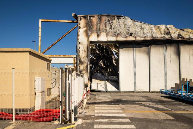 This photograph shows a damaged building of 'Catana Group', a company that manufactures and sells catamarans, a day after a fire broke out, in Canet-en-Roussillon, southern France on July 3, 2026. Nearly 3,000 people had to be evacuated from several campsites, as well as from businesses and several municipalities, after a fire broke out in Sainte-Marie-la-Mer and spread on to Canet-en-Roussillon, affecting the watersports hub, firefighters and the prefect of Pyrenees-Orientales said on July 2, 2026. (Photo by Jean-Christophe MILHET / AFP)