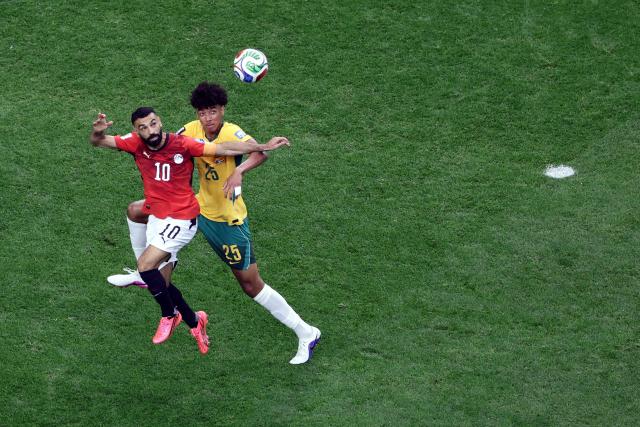 Australia's defender #25 Lucas Herrington (R) and Egypt's forward #10 Mohamed Salah jump for the ball  during the 2026 World Cup round of 32 football match between Australia and Egypt at the Dallas Stadium in Arlington on July 3, 2026.  (Photo by Aric Becker / AFP)