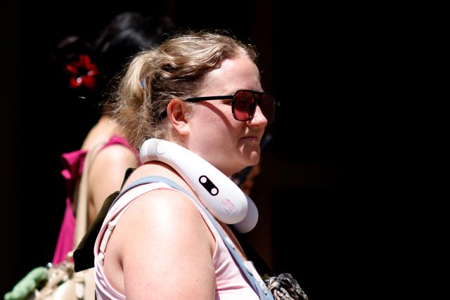 A woman uses a personal fan in midtown Manhattan during a heatwave in New York on July 3, 2026. Blistering temperatures and humidity has gripped swaths of the United States this week, with more to come for the densely populated East Coast as the nation co-hosts the World Cup and prepares to celebrate its 250th birthday on July 4. The heat wave that has been broiling the Midwest is intensifying in the Northeast, with temperatures surpassing 100F (38C) in cities including New York, Philadelphia and Washington. (Photo by Leonardo MUNOZ / AFP)