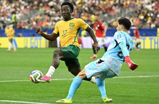Australia's forward #17 Nestory Irankunda (L) fights for the ball with Egypt's goalkeeper #23 Mostafa Shoubir during the 2026 World Cup round of 32 football match between Australia and Egypt at the Dallas Stadium in Arlington on July 3, 2026.  (Photo by Paul ELLIS / AFP)