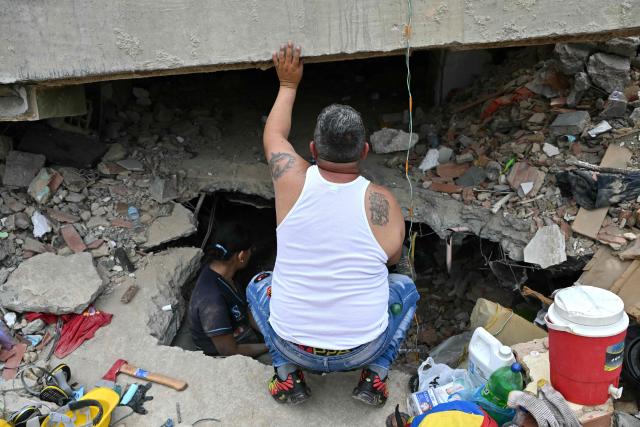 Relatives search for loved ones in a collapsed building in Caraballeda, La Guaira state, Venezuela, on July 3, 2026. The death toll from Venezuela's twin earthquakes has risen to 2,595, Interim President Delcy Rodriguez said on July 2. (Photo by MARTIN BERNETTI / AFP)