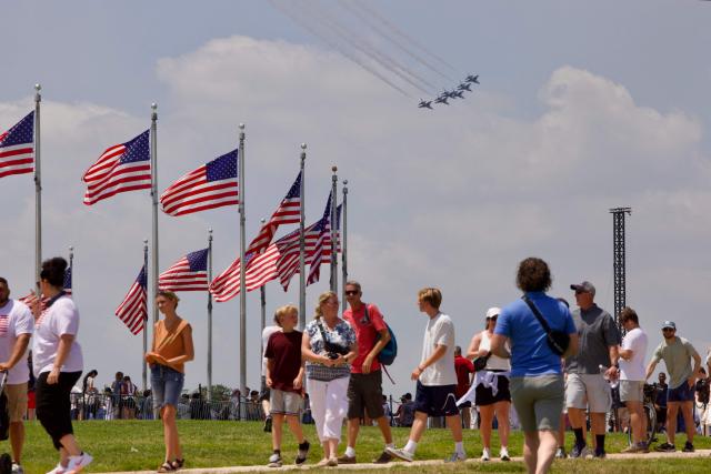 People gather on the National Mall as a US Air Force Thunderbirds demonstration squadron flies overhead in Washington, DC, on July 3, 2026, ahead of the upcoming July 4 holiday. (Photo by Amid FARAHI / AFP)