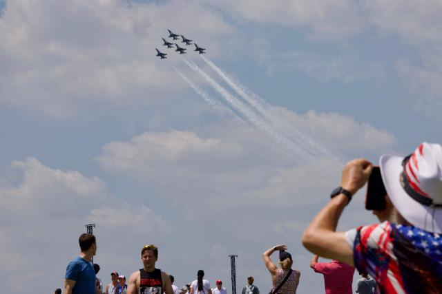 People gather on the National Mall as a US Air Force Thunderbirds demonstration squadron flies overhead in Washington, DC, on July 3, 2026, ahead of the upcoming July 4 holiday. (Photo by Amid FARAHI / AFP)