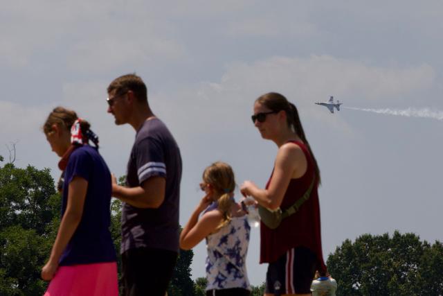 People gather on the National Mall as a US Air Force Thunderbirds demonstration squadron flies overhead in Washington, DC, on July 3, 2026, ahead of the upcoming July 4 holiday. (Photo by Amid FARAHI / AFP)