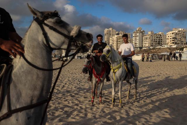Palestinians ride their horses on the beach front in Gaza City on July 3, 2026. The Gaza war was triggered by Hamas's October 7, 2023 attack on Israel, prompting Israel to launch a retaliatory campaign against the territory. A ceasefire took hold in October but progress on permanently ending the war has stalled, and Israeli forces currently control nearly 70 percent of the territory. (Photo by EYAD BABA / AFP)