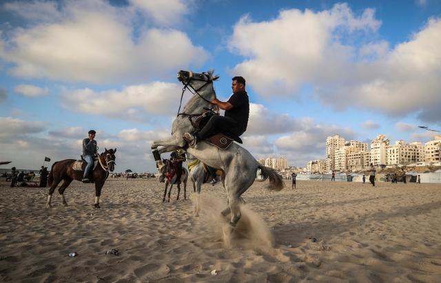A Palestinian man rides his horse on the beach in Gaza City on July 3, 2026. The Gaza war was triggered by Hamas's October 7, 2023 attack on Israel, prompting Israel to launch a retaliatory campaign against the territory. A ceasefire took hold in October but progress on permanently ending the war has stalled, and Israeli forces currently control nearly 70 percent of the territory. (Photo by EYAD BABA / AFP)