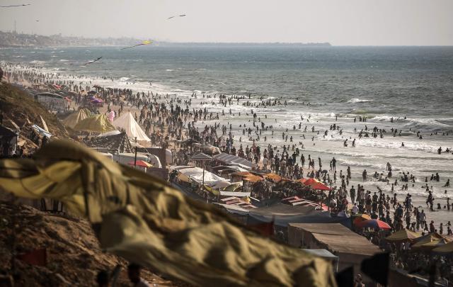 Palestinians gather along on the beach front in Gaza City on July 3, 2026. The Gaza war was triggered by Hamas's October 7, 2023 attack on Israel, prompting Israel to launch a retaliatory campaign against the territory. A ceasefire took hold in October but progress on permanently ending the war has stalled, and Israeli forces currently control nearly 70 percent of the territory. (Photo by EYAD BABA / AFP)