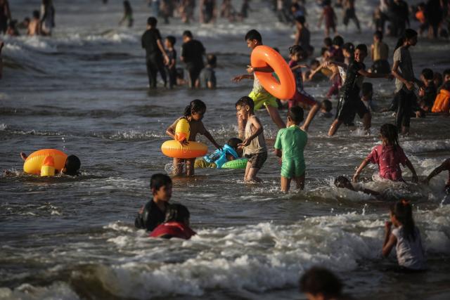 Palestinian children swim in the ocean in Gaza City on July 9, 2026. The Gaza war was triggered by Hamas's October 7, 2023 attack on Israel, prompting Israel to launch a retaliatory campaign against the territory. A ceasefire took hold in October but progress on permanently ending the war has stalled, and Israeli forces currently control nearly 70 percent of the territory. (Photo by EYAD BABA / AFP)