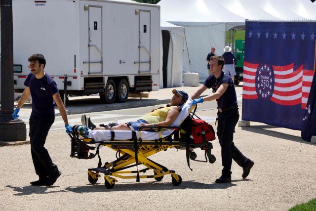 A person is helped by first responders as people cope with extreme heat along the National Mall in Washington, DC, on July 3, 2026, as high temperatures grip the US capital ahead of Independence Day celebrations. Blistering temperatures and humidity has gripped swaths of the United States this week, with more to come for the densely populated East Coast as the nation co-hosts the World Cup and prepares to celebrate its 250th birthday on July 4. The heat wave that has been broiling the Midwest is intensifying in the Northeast, with temperatures surpassing 100F (38C) in cities including New York, Philadelphia and Washington. (Photo by Amid FARAHI / AFP)
