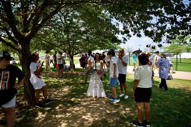 People seek the shade beneath a tree to cope with extreme heat along the National Mall in Washington, DC, on July 3, 2026, as high temperatures grip the US capital ahead of Independence Day celebrations. Blistering temperatures and humidity has gripped swaths of the United States this week, with more to come for the densely populated East Coast as the nation co-hosts the World Cup and prepares to celebrate its 250th birthday on July 4. The heat wave that has been broiling the Midwest is intensifying in the Northeast, with temperatures surpassing 100F (38C) in cities including New York, Philadelphia and Washington. (Photo by Amid FARAHI / AFP)