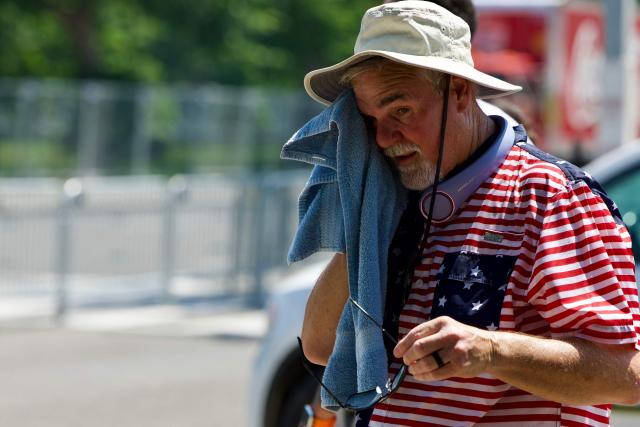 A man wipes himself off as people cope with extreme heat along the National Mall in Washington, DC, on July 3, 2026, as high temperatures grip the US capital ahead of Independence Day celebrations. Blistering temperatures and humidity has gripped swaths of the United States this week, with more to come for the densely populated East Coast as the nation co-hosts the World Cup and prepares to celebrate its 250th birthday on July 4. The heat wave that has been broiling the Midwest is intensifying in the Northeast, with temperatures surpassing 100F (38C) in cities including New York, Philadelphia and Washington. (Photo by Amid FARAHI / AFP)