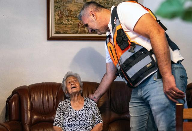 Maria Rosel, 94, speaks with the Civil Protection Municipal Coordinator Filipe Almeirante while taking refuge inside her house due to high temperatures hitting the area, on July 3, 2026, in Vale de Figueira, Santarem, Portugal. Parts of Portugal are under red alert due to forecast high temperatures in the coming days after being relatively spared by the recent European heatwave, with the IPMA weather agency placing regions including Leiria and Coimbra on alert through Friday as temperatures could reach 44°C in some areas. (Photo by HENRIQUE CASINHAS / AFP)