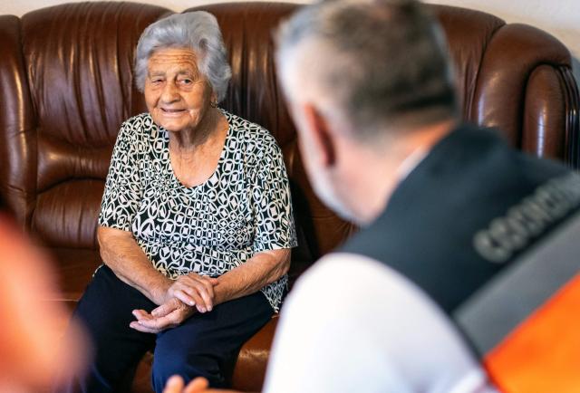 Maria Rosel, 94, speaks with the Civil Protection Municipal Coordinator Filipe Almeirante while taking refuge inside her house due to high temperatures hitting the area, on July 3, 2026, in Vale de Figueira, Santarem, Portugal. Parts of Portugal are under red alert due to forecast high temperatures in the coming days after being relatively spared by the recent European heatwave, with the IPMA weather agency placing regions including Leiria and Coimbra on alert through Friday as temperatures could reach 44°C in some areas. (Photo by HENRIQUE CASINHAS / AFP)