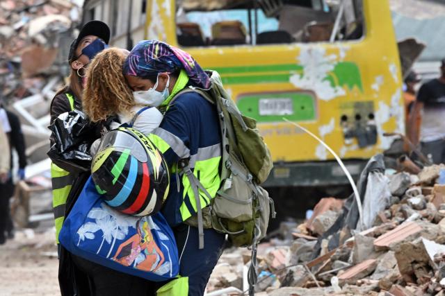 Volunteers comfort a person after the body of a relative was recovered from the rubble of a collapsed building in Caraballeda, La Guaira state, Venezuela, on July 3, 2026. The death toll from Venezuela's devastating twin earthquakes has risen to 2,645, with more than 12,600 injured, according to new official figures released on July 3. (Photo by MARTIN BERNETTI / AFP)