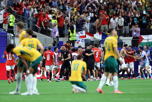 Egypt's players celebrate as Australia's players react after winning the 2026 World Cup round of 32 football match between Australia and Egypt at the Dallas Stadium in Arlington on July 3, 2026.  (Photo by Thomas COEX / AFP)