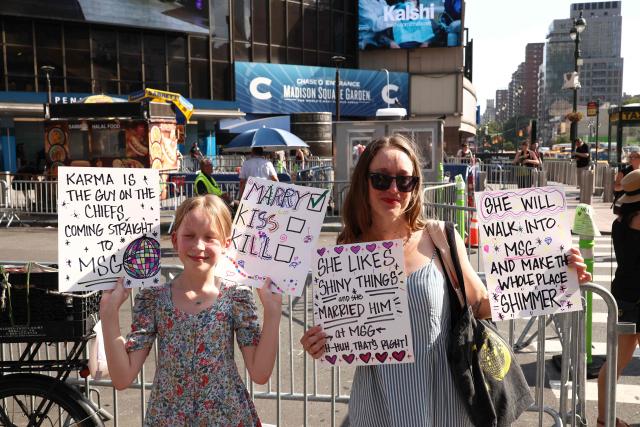 Taylor Swift fans hold signs outside Madison Square Garden, the reported venue for the wedding celebrations of pop singer Taylor Swift and pro-athlete Travis Kelce, in New York City on July 3, 2026. Swift and Kelce's official wedding plans are tightly under wraps, but New York is bracing to host the celebrity marriage of the year this week at Madison Square Garden. The wedding will reportedly take place Friday with a star-studded guest list of around 1,000, including models Gigi Hadid and Cara Delevingne, singer Selena Gomez, and actress Zoe Kravitz -- all known to be close Swift pals -- and Kelce's Kansas City Chiefs teammates. (Photo by CHARLY TRIBALLEAU / AFP)