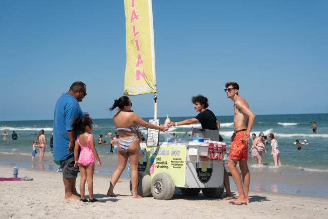 People order Italian Ice from a cart during a heatwave in Carolina Beach, North Carolina, on July 3, 2026. Blistering temperatures and humidity has gripped swaths of the United States this week, with more to come for the densely populated East Coast as the nation co-hosts the World Cup and prepares to celebrate its 250th birthday on July 4. The heat wave that has been broiling the Midwest is intensifying in the Northeast, with temperatures surpassing 100F (38C) in cities including New York, Philadelphia and Washington. (Photo by Allison Joyce / AFP)