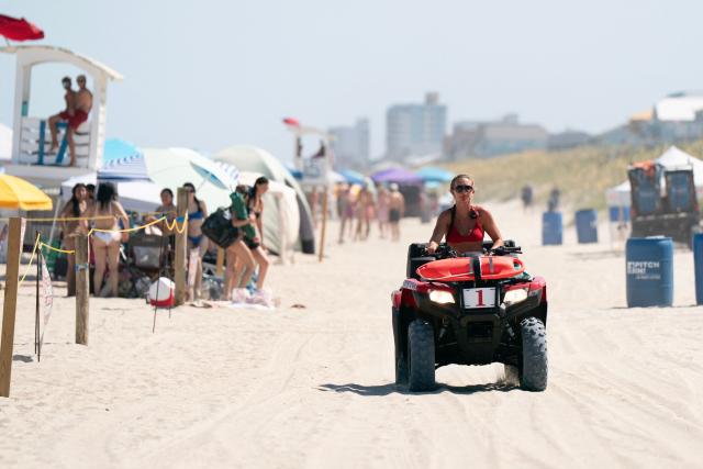 A lifeguard rides on an ATV during a heatwave in Carolina Beach, North Carolina, on July 3, 2026. Blistering temperatures and humidity has gripped swaths of the United States this week, with more to come for the densely populated East Coast as the nation co-hosts the World Cup and prepares to celebrate its 250th birthday on July 4. The heat wave that has been broiling the Midwest is intensifying in the Northeast, with temperatures surpassing 100F (38C) in cities including New York, Philadelphia and Washington. (Photo by Allison Joyce / AFP)