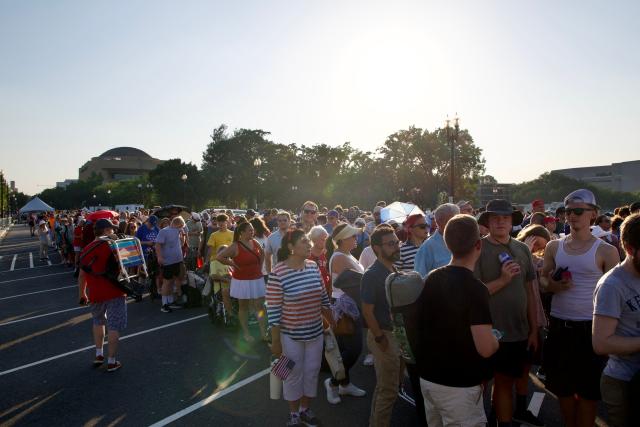 People wait in line for a concert at the US Capitol while dealing with extreme heat along the National Mall in Washington, DC, on July 3, 2026. Blistering temperatures and humidity has gripped swaths of the United States this week, with more to come for the densely populated East Coast as the nation co-hosts the World Cup and prepares to celebrate its 250th birthday on July 4. The heat wave that has been broiling the Midwest is intensifying in the Northeast, with temperatures surpassing 100F (38C) in cities including New York, Philadelphia and Washington. (Photo by Amid FARAHI / AFP)