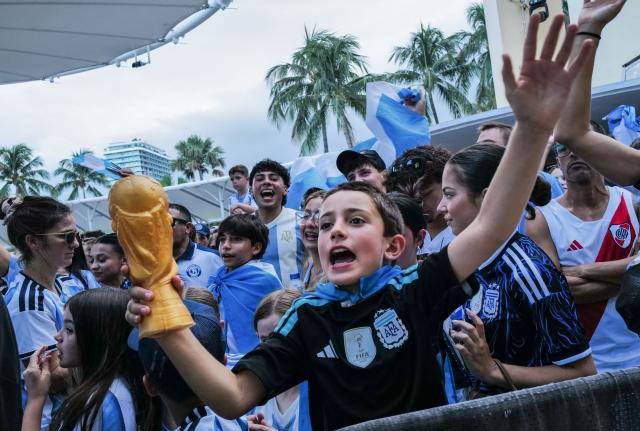 A young Argentina fan holds a plastic World CUp trophy as people gather to watch the 2026 World Cup Round of 32 football match between Argentina and Cape Verde in Miami Beach, Florida, on July 3, 2026. (Photo by Giorgio VIERA / AFP)