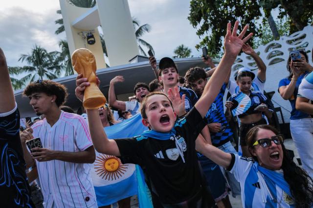 A young Argentina fan holds a plastic World CUp trophy as people gather to watch the 2026 World Cup Round of 32 football match between Argentina and Cape Verde in Miami Beach, Florida, on July 3, 2026. (Photo by Giorgio VIERA / AFP)