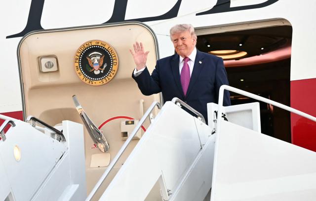 US President Donald Trump waves as he steps off Air Force One upon arriving at Ellsworth Air Force Base, South Dakota on July 3, 2026. Trump is heading to South Dakota where he will deliver remarks at Mt. Rushmore. (Photo by Mandel NGAN / AFP)