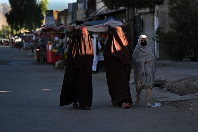 Afghan burqa-clad women walk along a street in Chonee village of Kandahar province on July 4, 2026. (Photo by Sanaullah SEIAM / AFP)