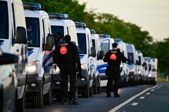 Police vehicles are stationed on an access road to the Messe Erfurt fairground in Erfurt, eastern Germany on July 4, 2026, in view of demonstrations against the party congress of far-right Alternative for Germany (AfD) that will be held from July 4-5. German police are bracing to guard an annual congress of the far-right AfD party this weekend against tens of thousands of antifascist demonstrators who are determined to shut it down. The standoff in the city of Erfurt, Thuringia state, comes as the opposition Alternative for Germany party is soaring in national opinion polls ahead of all other parties. (Photo by John MACDOUGALL / AFP)
