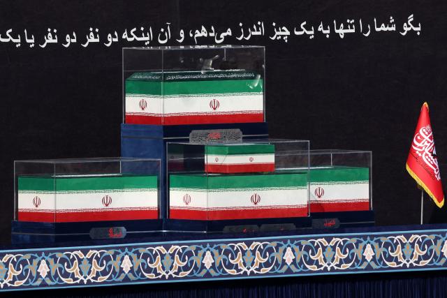The coffins of Iran's slain supreme leader Ayatollah Ali Khamenei and his family members are pictured at the Grand Mosalla at the start of the funeral ceremonies in Tehran on July 4, 2026. Funeral ceremonies for Iran's supreme leader Ali Khamenei officially began on July 4, state television reported, an event drawing thousands and intended to serve as a show of strength to the Islamic republic's foes. (Photo by ATTA KENARE / AFP) / 