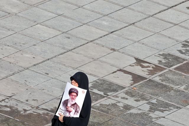 A mourner carries a portrait of Iran's slain supreme leader Ayatollah Ali Khamenei at the start of his funeral ceremonies at the Grand Mosalla in Tehran on July 4, 2026. Funeral ceremonies for Iran's supreme leader Ali Khamenei officially began on July 4, state television reported, an event drawing thousands and intended to serve as a show of strength to the Islamic republic's foes. (Photo by ATTA KENARE / AFP) / 