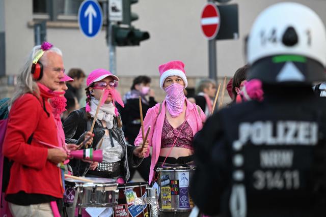 Demonstrators with drums face a police officer in Erfurt, eastern Germany on early July 4, 2026, as they protest against the party congress of far-right Alternative for Germany (AfD). German police are bracing to guard an annual congress of the far-right AfD party this weekend against tens of thousands of antifascist demonstrators who are determined to shut it down. The standoff in the city of Erfurt, Thuringia state, comes as the opposition Alternative for Germany party is soaring in national opinion polls ahead of all other parties. (Photo by RALF HIRSCHBERGER / AFP)
