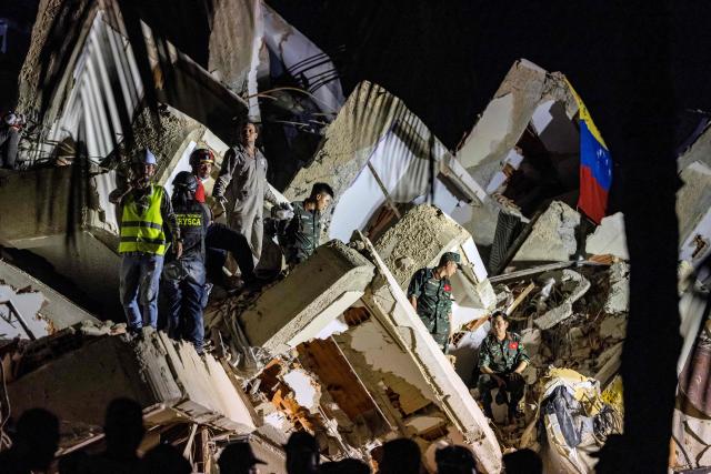 Vietnamese rescuers work among the ruins of the Oasis Beach residential building for a rescue operation during which they pulled out alive from the rubbles the police chief of La Guaira, Vice Admiral Gustavo Matamoros, in Playa Grande, La Guaira state, on July 3, 2026. The death toll from Venezuela's devastating twin earthquakes has risen to 2,645, with more than 12,600 injured and thousands mores reported still missing, according to new official figures. (Photo by Miguel MEDINA / AFP)