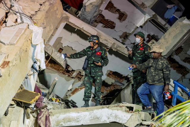 Vietnamese rescuers work among the ruins of the Oasis Beach residential building for a rescue operation during which they pulled out alive from the rubbles the police chief of La Guaira, Vice Admiral Gustavo Matamoros, in Playa Grande, La Guaira state, on July 3, 2026. The death toll from Venezuela's devastating twin earthquakes has risen to 2,645, with more than 12,600 injured and thousands mores reported still missing, according to new official figures. (Photo by Miguel MEDINA / AFP)
