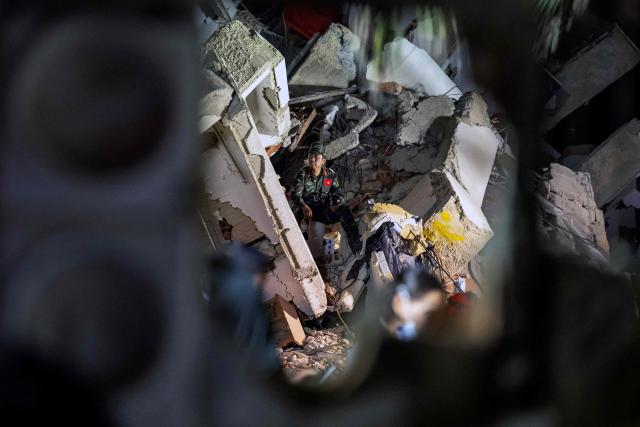Vietnamese rescuers work among the ruins of the Oasis Beach residential building for a rescue operation during which they pulled out alive from the rubbles the police chief of La Guaira, Vice Admiral Gustavo Matamoros, in Playa Grande, La Guaira state, on July 3, 2026. The death toll from Venezuela's devastating twin earthquakes has risen to 2,645, with more than 12,600 injured and thousands mores reported still missing, according to new official figures. (Photo by Miguel MEDINA / AFP)