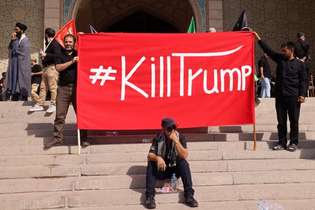 Mourners hold a banner at the Grand Mosalla during the funeral ceremonies of Iran's slain supreme leader Ayatollah Ali Khamenei, in Tehran on July 4, 2026. Vast crowds of Iranians loyal to the Islamic republic massed in Tehran on July 4 to begin almost a week of funeral ceremonies for slain supreme leader Ali Khamenei, which authorities want to send a message of defiance to the West after the war with the United States and Israel. (Photo by ATTA KENARE / AFP) / 