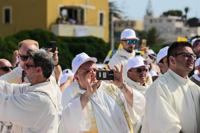 Faithfuls gather to attend the mass celebrated by Pope Leo XIV during a one day visit to Lampedusa island, south of Sicily, on July 4, 2026. Pope Leo XIV bid Europe on July 4 better its response to the "momentous challenge" of migration, urging it to adopt a strategic approach to integrating new arrivals, as well as improving lives in developing countries. (Photo by Tiziana FABI / AFP)